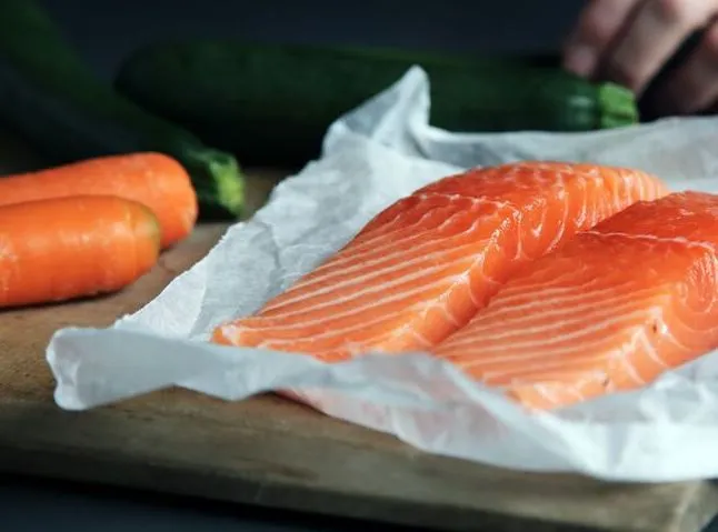 Salmon fillets and carrots on a cutting board