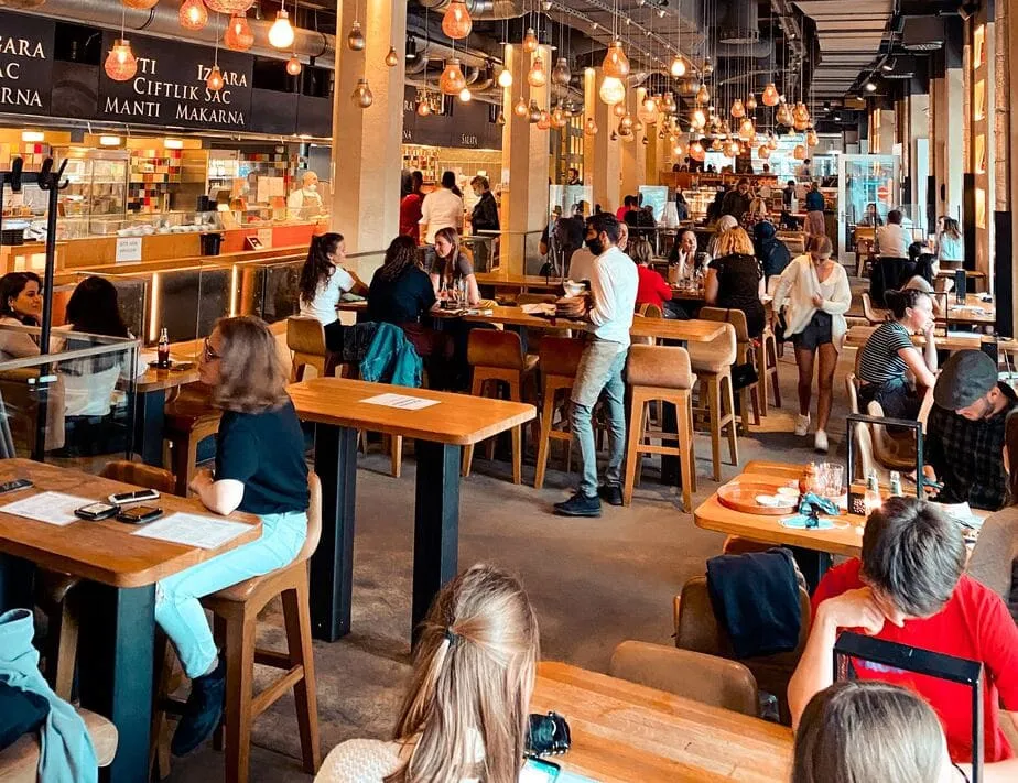 Customers seated at tables in a food hall